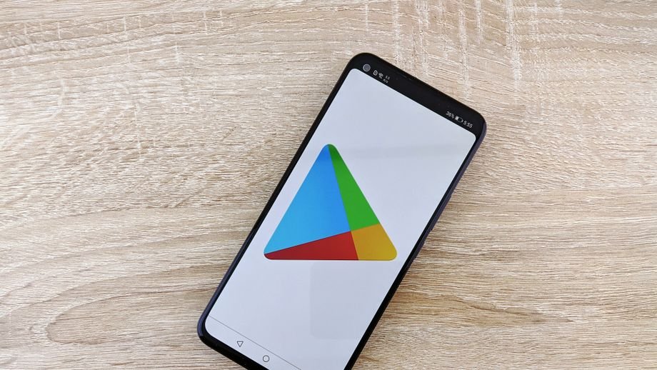High-angle view of smartphone with app store icon on screen placed on wooden tabletop.