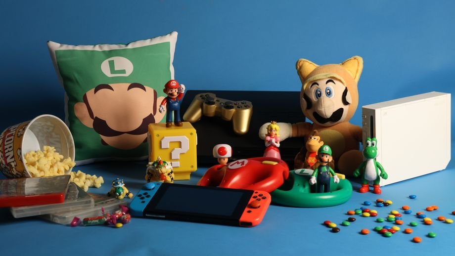 A vibrant assortment of gaming collectibles, including Nintendo figures, consoles, and candy on a blue background.