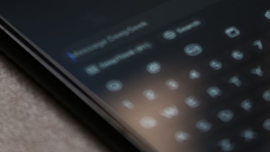 Close-up of smartphone screen showing AI chatbot interface on dark mode with text input.